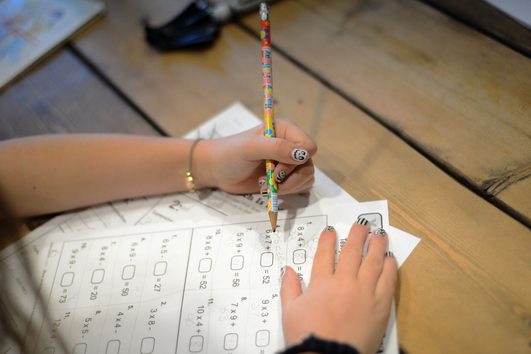 Maggie Reeves, 10, solves math problems at the kitchen table